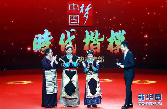 被授予“时代楷模”称号的卓嘎（右二）、央宗（左二）姐妹在“时代楷模”授予仪式上与主持人和观众互动交流（2018年10月16日摄）。新华社记者 潘旭 摄